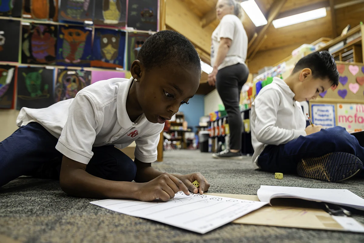 Primary school writing in a workbook.