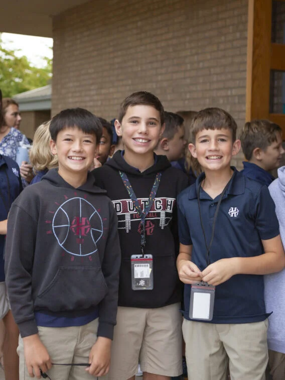 Three middle school students posing together.