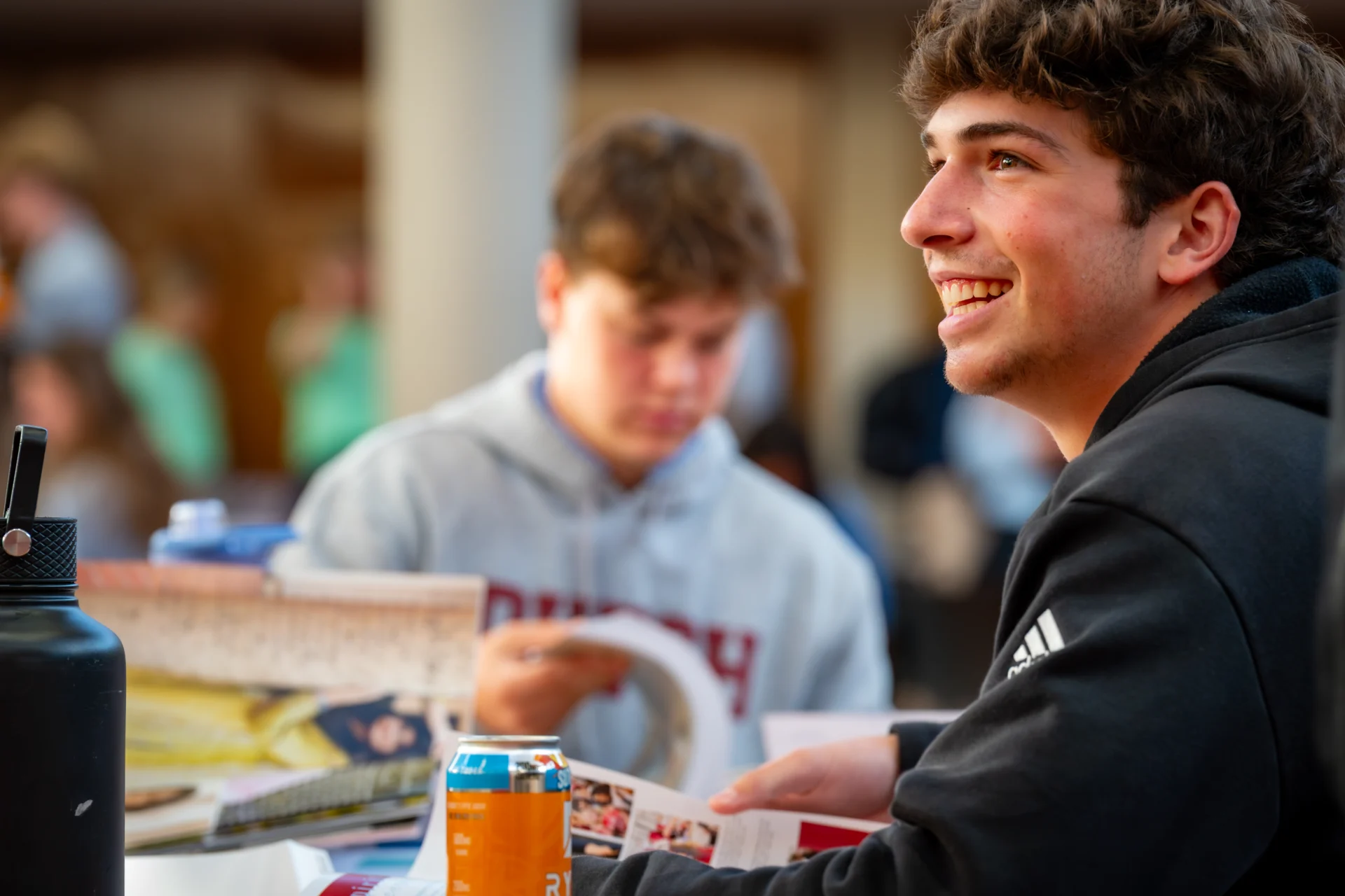 Student smiling while in a discussion with other students during the Yearbook Party.