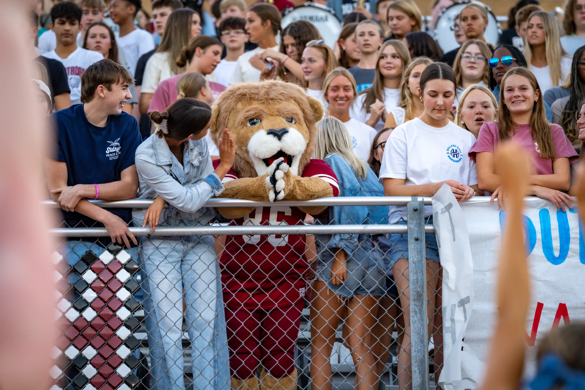 Cheering crowd in the stands at a football game with the mascot, Dutch, in the center.