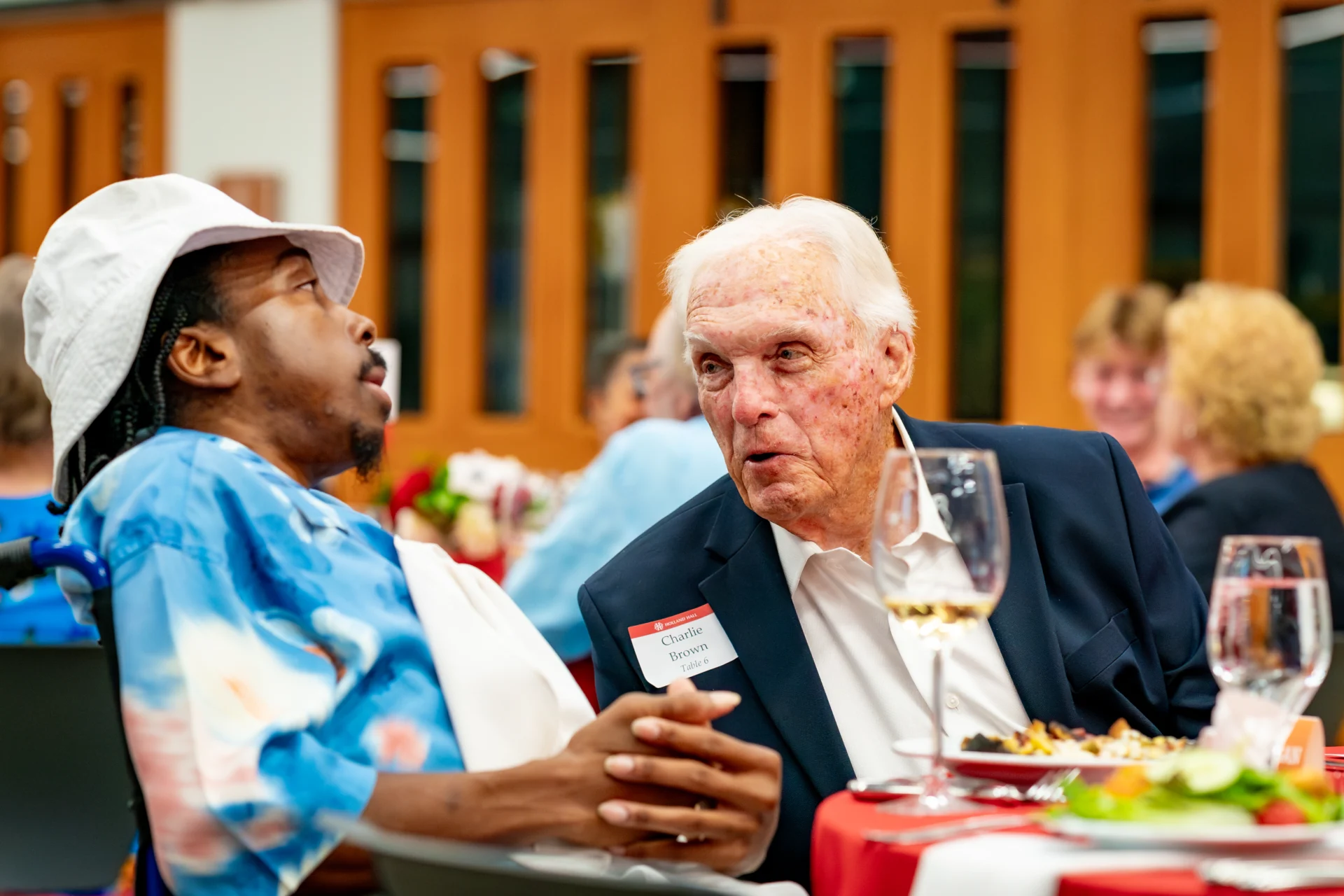 Candid photo of two alumni speaking at a table during the Distinguished Alumni Awards dinner.