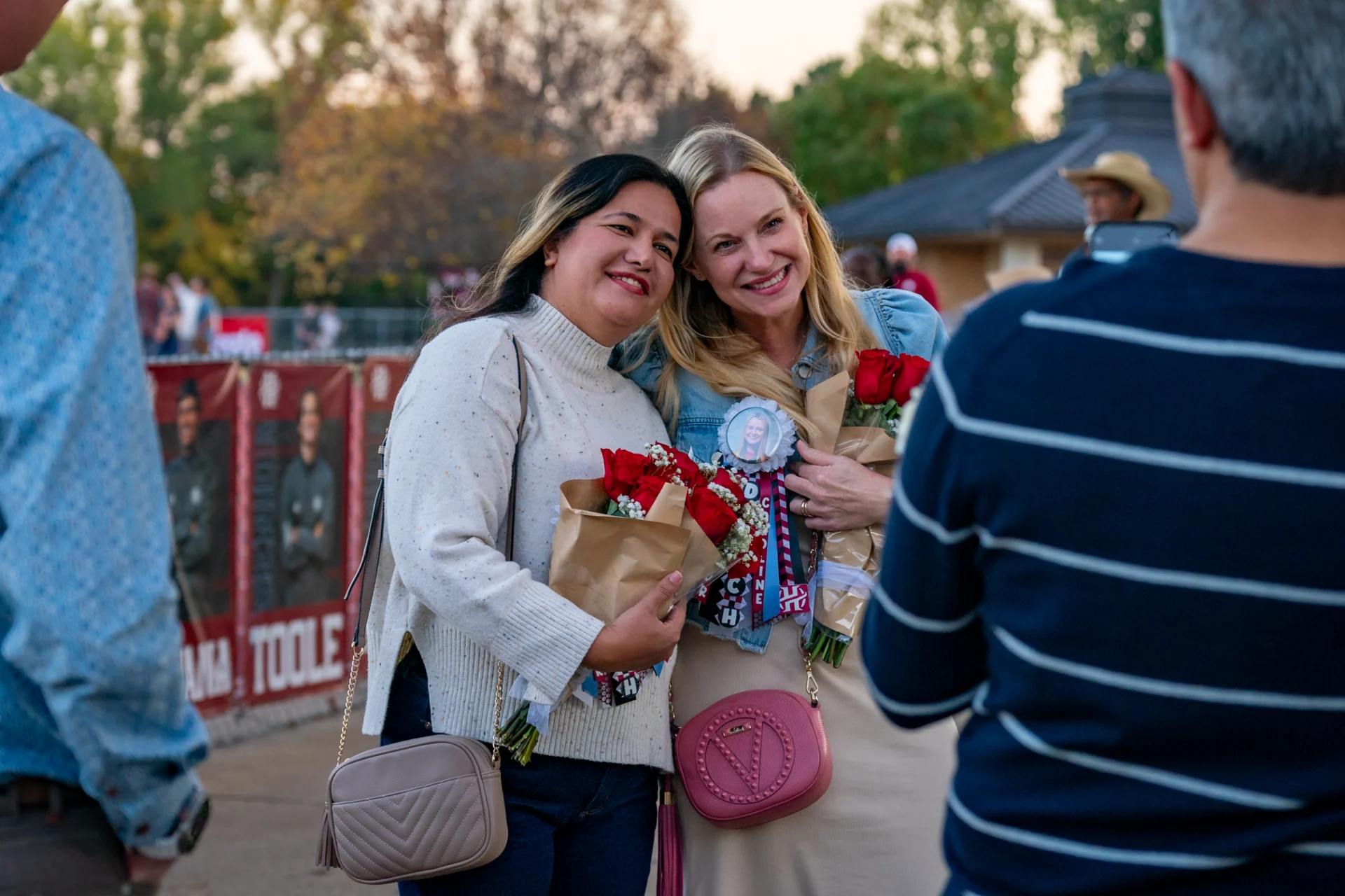 two alumni posing during the Alumni Weekend and HoCo Football game.