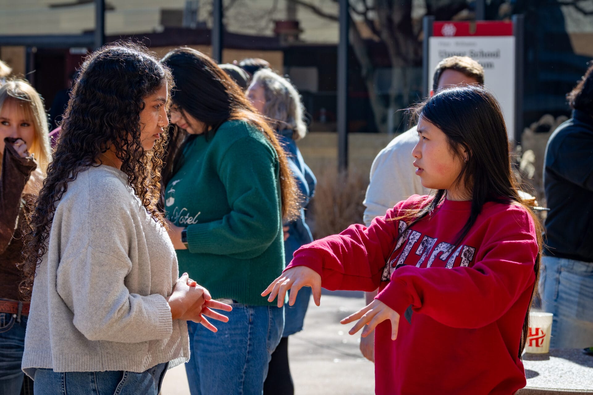 Members of the Class of 2025 come back for a lunch on campus. Two students stand in front of the Upper School gym.